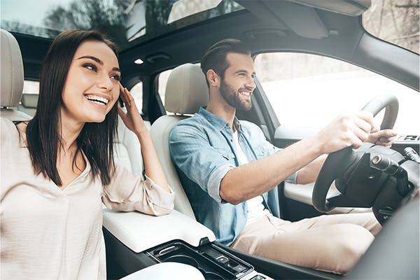 Young-couple-sitting-on-the-front-passenger-seats