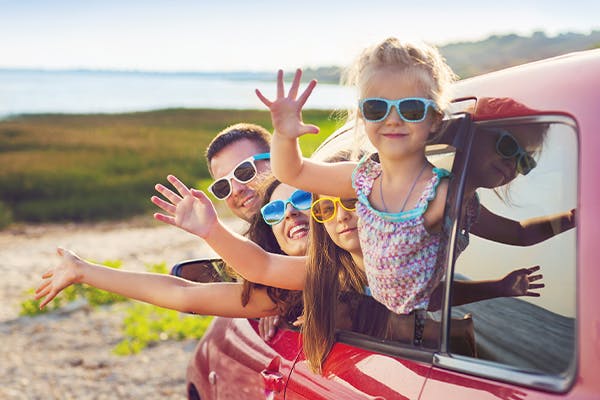 smiling-family-with-two-children-at-beach-in-the-car.
